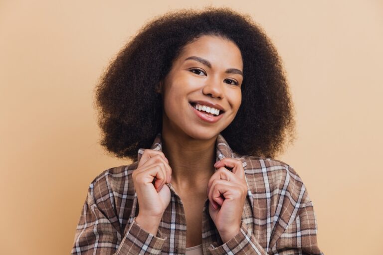 African,American,Woman,Smiling,,Pulling,Her,Plaid,Shirt,Collar,Against